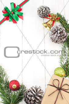 Christmas background with decorations and gift box on white wooden board.
