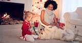 Mom and daughter in sweaters play with pet dog