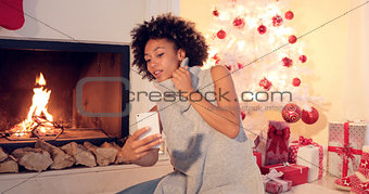 Stylish young woman taking a Christmas selfie