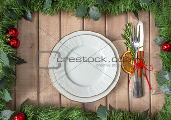 Christmas table layout, red tape with a cinnamon stick, rosmarin and a slice of dry orange