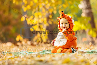 Cute baby boy dressed in fox costume in park