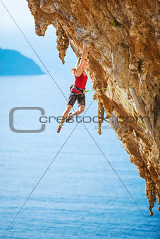 Young female rock climber on a cliff.