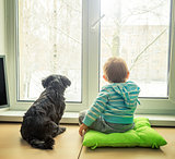Baby with Dog Looking through a Window in Winter