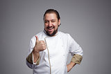 Pleased chef laughs and shows thumbs up.