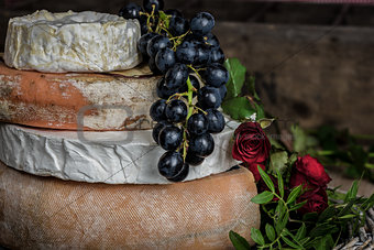 aged cheese wheels concord grapes with long stem red roses