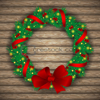 Christmas wreath with baubles and treeon background of boards.
