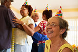 Senior Friends Dancing At Birthday Party In Hospice