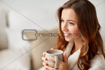 happy woman with cup of cocoa or coffee at home