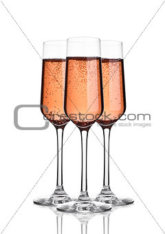 Glass of pink rose champagne with bubbles on white