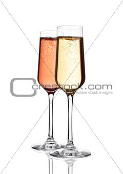 Glasses of pink  and yellow champagne on white