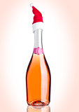 Bottle of pink rose champagne with santa hat pink