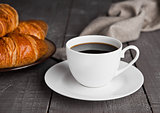 Cup of black coffee and croissant for breakfast