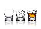 Glasss of whiskey with ice cubes with reflection