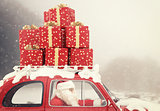 Santa Claus on a red car full of Christmas present