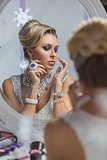 Beautiful bride looking in mirror