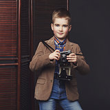 Handsome young boy with retro camera