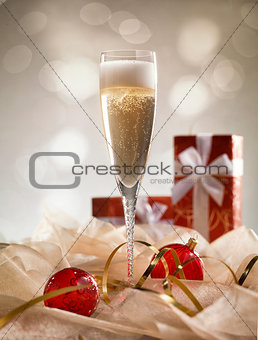 Christmas glasses of Champagne and golden background with red gi