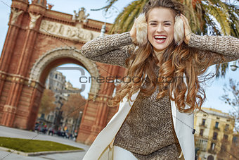 cheerful young fashion-monger in earmuffs in Barcelona, Spain