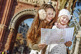happy mother and daughter in Barcelona, Spain looking at map