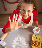Young housewife showing hand smeared in flour