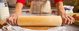 Closeup on housewife rolling out dough with rolling pin