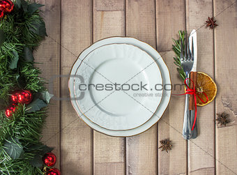 Christmas table layout, red tape with a cinnamon stick, rosmarin and a slice of dry orange