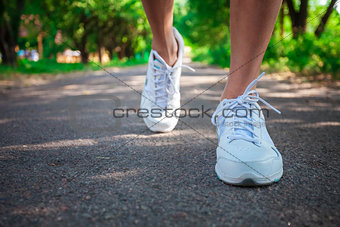 Cropped view of woman athlete running on pathway in park