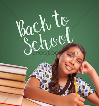 Cute Hispanic Girl Studying In Front of Back To School Written o