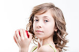 girl about to bite a red apple on white background