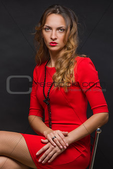 The beautiful young girl in a bright red dress