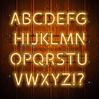 Glowing Neon Alphabet on Wooden Background