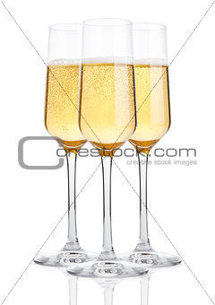 Glasses of champagne with bubbles on white