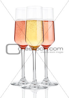Glasses of champagne with bubbles on white