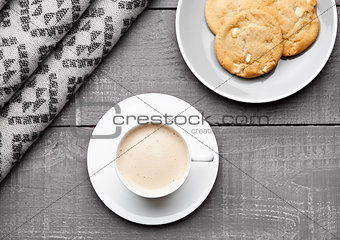 Cup of cappuccino with grey wool scarf and cookies