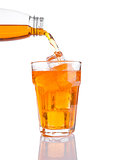 Pouring orange energy soda drink in glass with ice