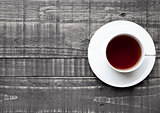 Cup of black healthy tea on wood