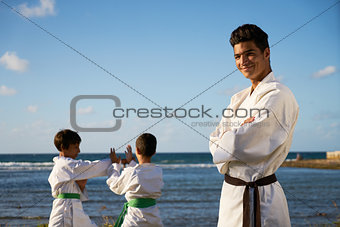 Happy Karate Sport Instructor Watching Young Boys Fighting