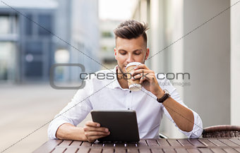 man with tablet pc and coffee at city cafe