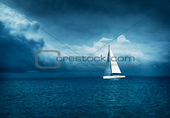 White Yacht Sailing in Stormy Sea. Dark Photo.
