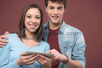 Smiling teens using a digital tablet