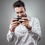 Handsome man playing with his smartphone
