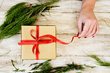 woman tying a gift wit red ribbon