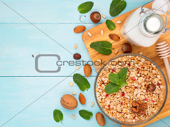 Muesli, milk and nuts on blue background