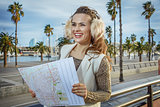 woman on embankment in Barcelona with map looking into distance
