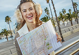 happy young tourist woman in Barcelona, Spain with map