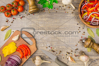 Ingredients for food onion pepper garlic and utensils on a wooden table.  top view of  plate  vegetables greens,  copy space