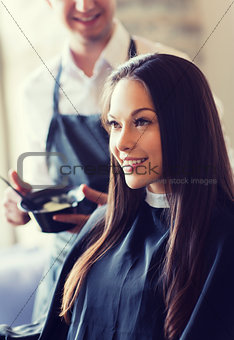 happy young woman coloring hair at salon