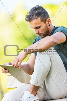 handsome man outdoors with a tablet