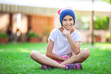 Cheerful young girl sitting on the grass