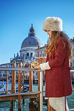 fashion-monger on embankment looking on Venetian mask